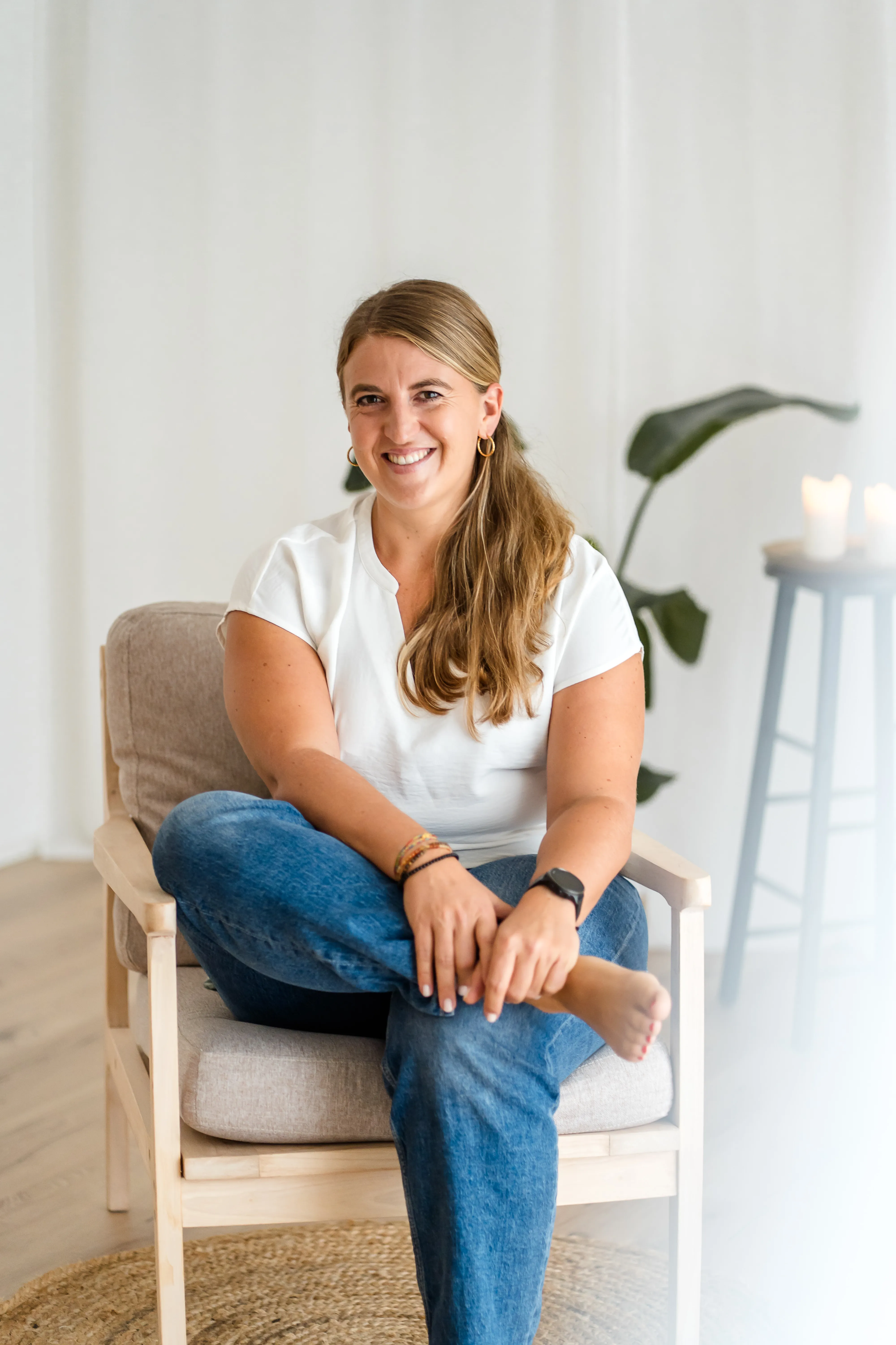 Stefanie Kaindl sitzt lächelnd in ihrem Behandlungsraum